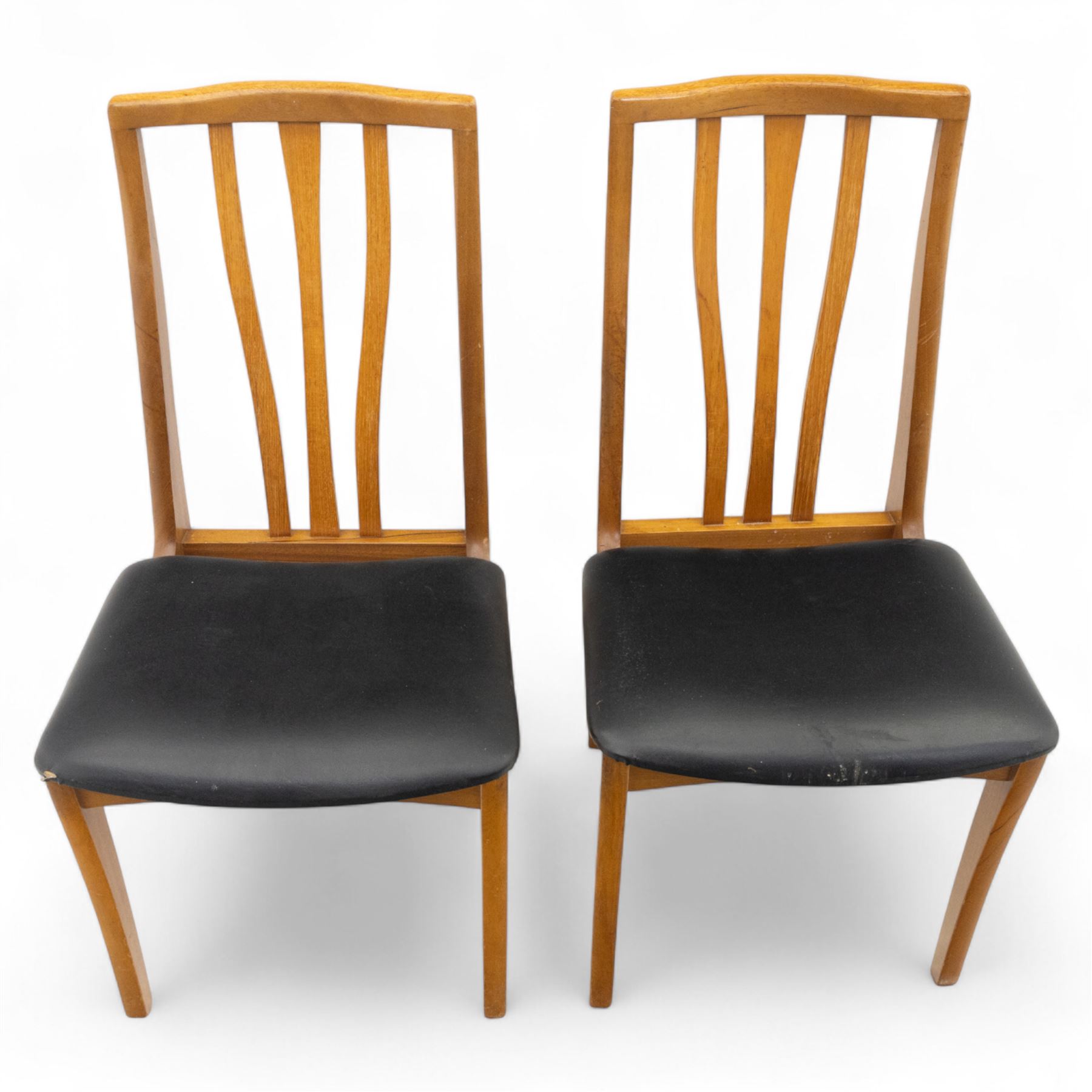 Sutcliffe of Todmorden - mid 20th century ‘S-Form’ teak dining table and chairs, the circular storable extending table with plain veneered top on tapered supports, together with matching dining chairs upholstered in black vinyl, with curved slat backs and shaped front supports, reflecting the sleek organic styling characteristic of 1960s British modern furniture design (Chairs H 93cm, W 46cm, D 46cm) (Extended 168cm)