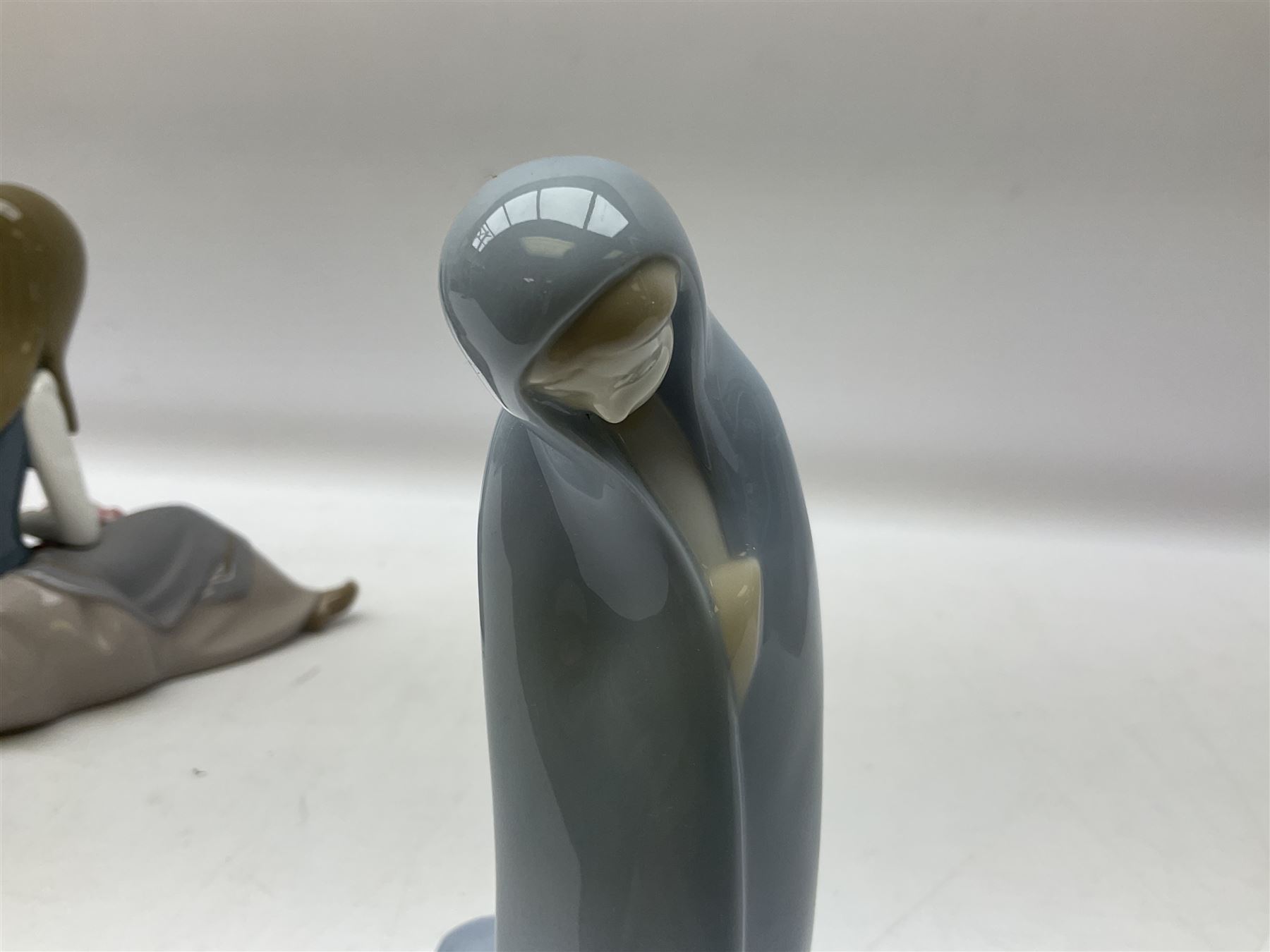 Four Lladro figures, comprising Afternoon Promenade no 7636, Nostalgia no 5071, both with original boxes, Girl with Lilies no 4972 and Madonna no 4534, largest example H27cm