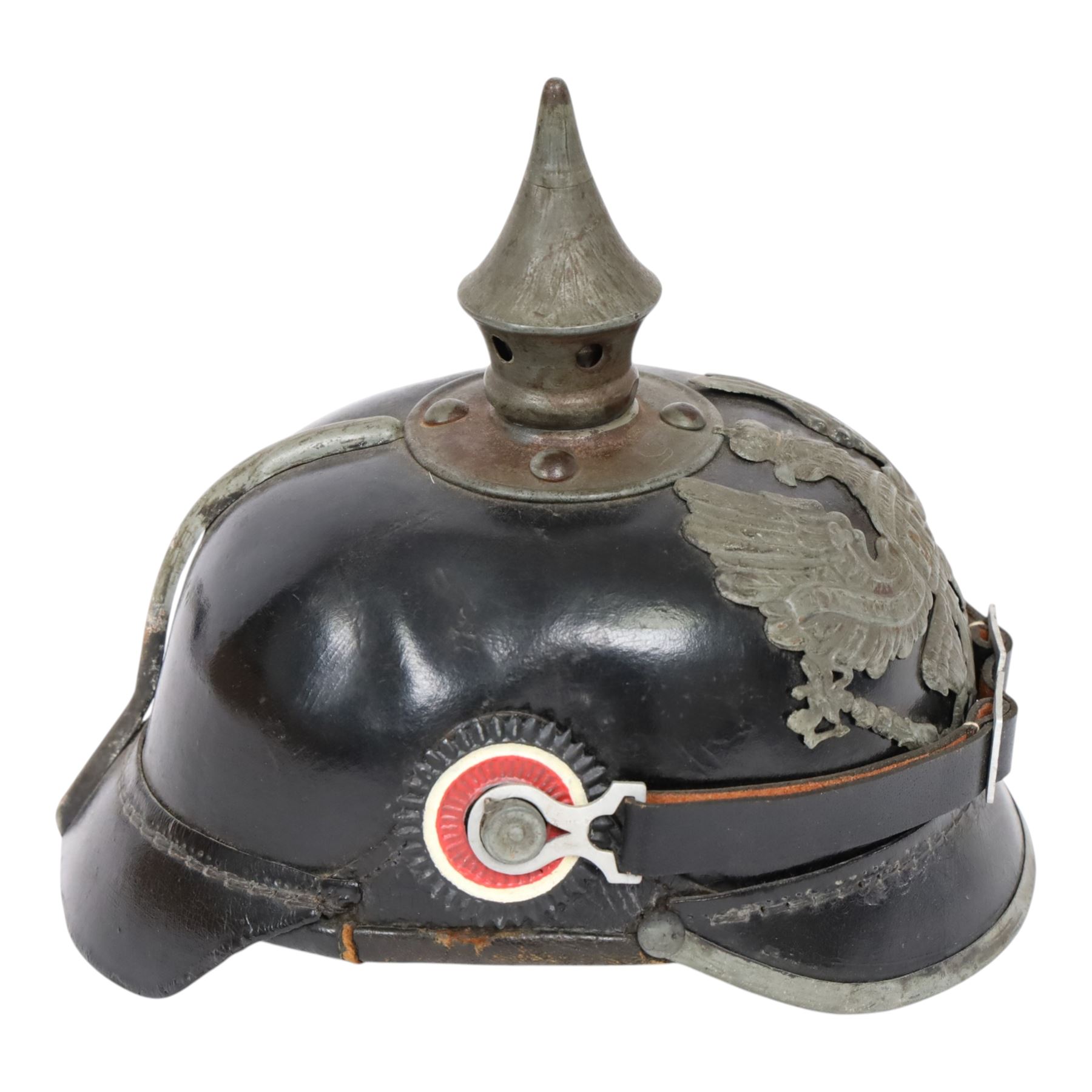 WWI Prussian M1915 Pickelhaube, the black leather skull with removable steel spike finial, steel eagle helmet plate and leather chin strap, one side with a black cockade, the other black and red