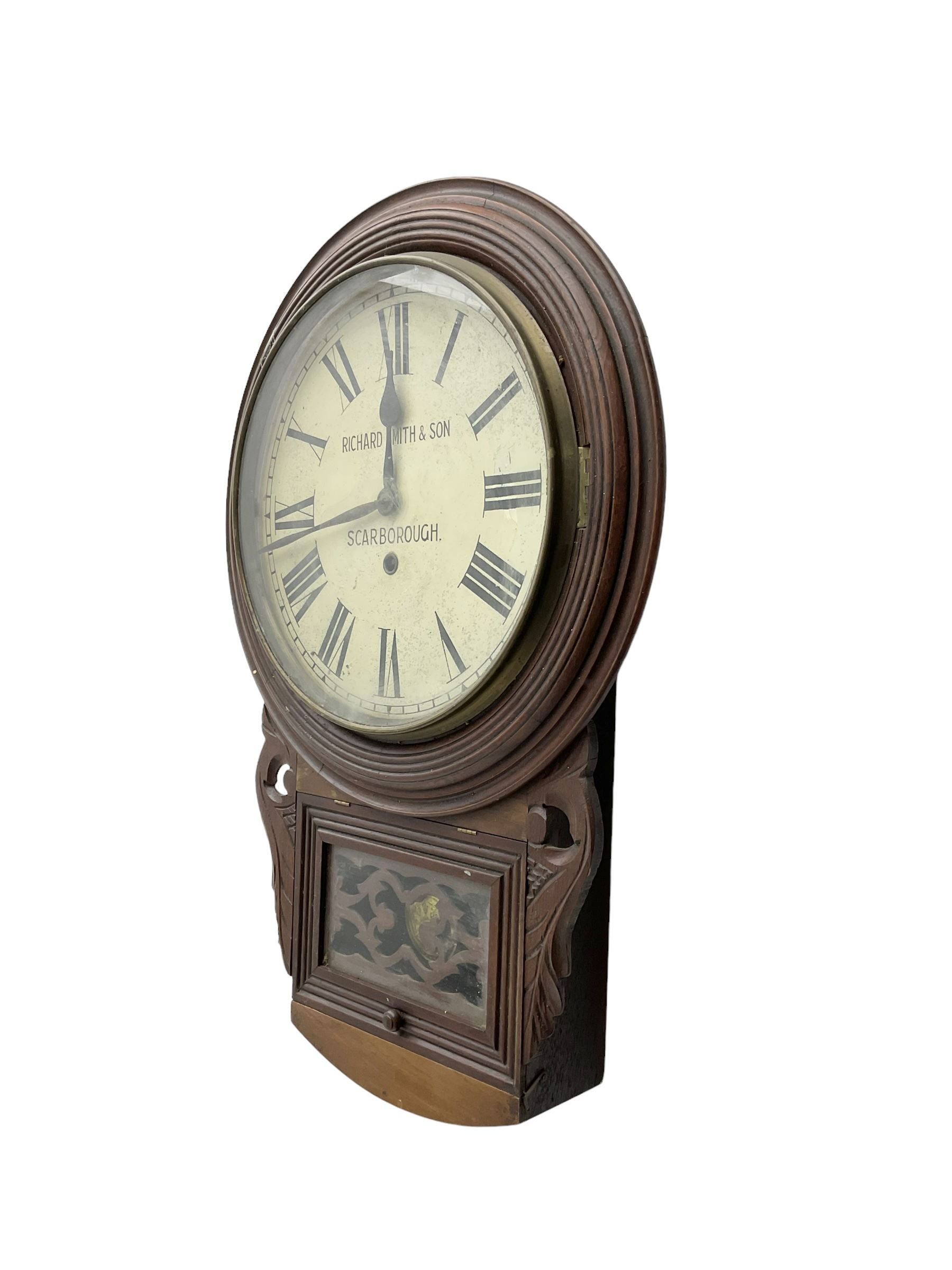 Richard Smith & Son, Scarborough - drop dial 8-day mahogany wall clock, with a turned wooden bezel, carved ear pieces and pendulum box with a glazed door and open carved fretwork,12