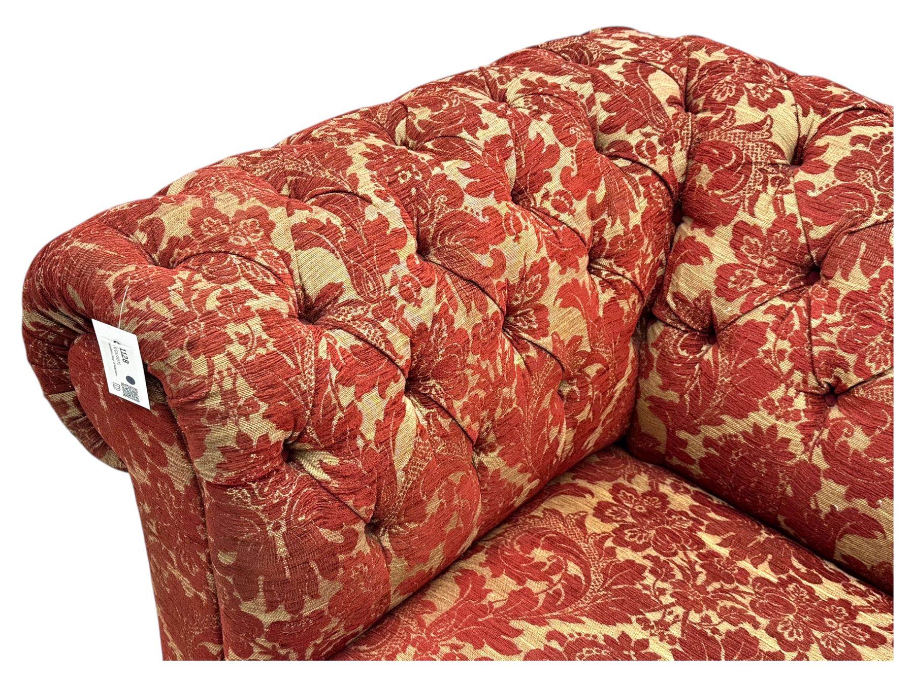 Late 20th century upholstered Chesterfield sofa, in red damask floral fabric, with deep buttoned back and arms, scrolled arms at equal height to back, on turned front supports