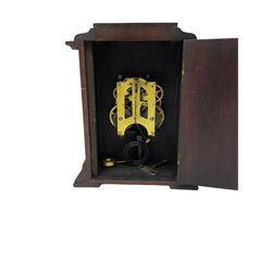 An American Mantle clock in a mahogany case with an eight-day “Ansonia” striking movement, case with a flat top and reeded pillars on a broad plinth with raised feet, square engraved and silvered dial with roman numerals and minute track, steel spade hands and pendulum regulation, sounding the hours and half hours on a coiled gong. With pendulum and key.  





