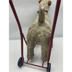 Tri ang - Pedigree Soft Toys - push along/ride-on dog as a wood wool filled plush Airedale terrier in red tubular frame with beech footrests and black rubber wheels; stitched Northern Ireland label in tact L60cm H61cm