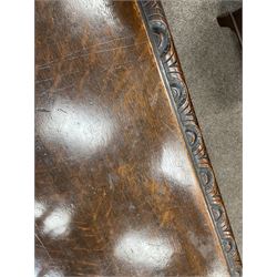 Large 19th century carved oak library table, the rectangular top with lunette carved edge over cartouche panelled and carved  scroll frieze, the central tapering rectangular support relief carved with masks and garlands, on four carved seated lion supports at each corner, on flat angular stretcher with recessed castors stamped ‘Bartholomew & Fletcher, London’