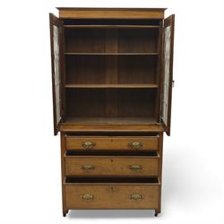 20th century wooden bookcase cabinet, fitted with a pair of leaded glass panel doors opening to adjustable shelves, the base top and front veneered in richly figured walnut, contrasted with solid oak panelled sides and shaped lower frieze, terminating in castors