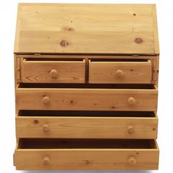 Contemporary waxed pine bureau, fall front enclosing fitted interior with pigeonholes and drawers, over two short and three long drawers with turned wooden knobs, on plinth base