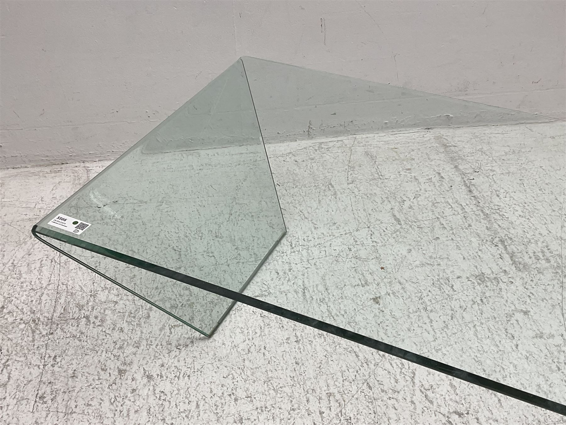 Contemporary glass coffee table, rectangular top with polished edge, on shaped end supports