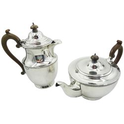 1920's silver teapot and hot water pot, each with foliate scroll band to body and stained wooden handle and finial, hallmarked William Neale & Son Ltd, Birmingham 1923 and 1924, including handle teapot H14.5cm hot water pot H20.5cm approximate total gross weight 32.17 ozt (1000.7 grams)