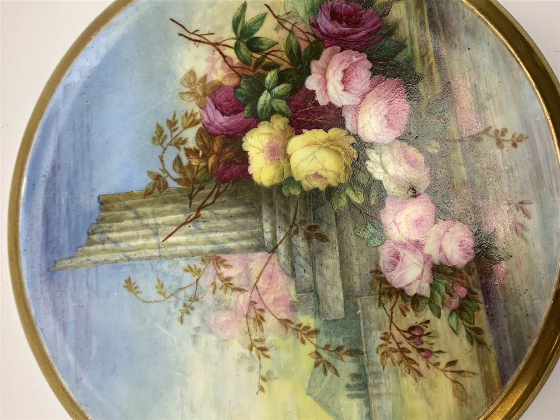 19th century porcelain stand, of circular form, in the Derby style, hand painted with a ruinous column and roses against a landscape background, within a gilt border, D7cm