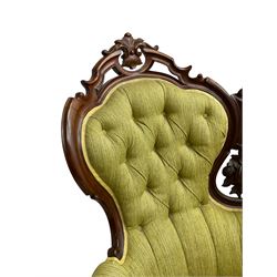 Victorian walnut settee, triple back with pierced and scroll-carved cresting rails over carved fruit and foliage decoration, upholstered in buttoned green fabric, serpentine seat and carved apron, on cabriole feet