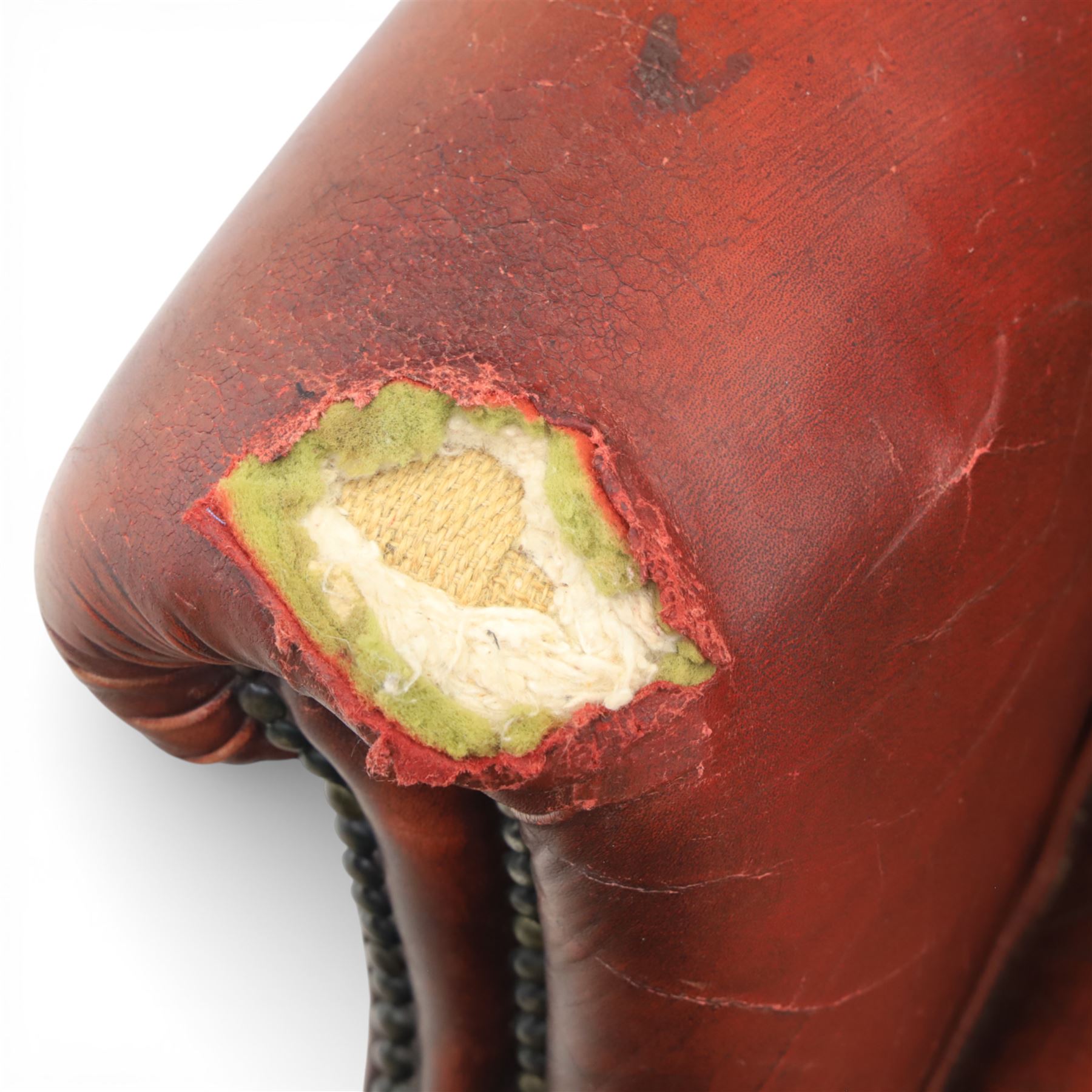 Georgian design wingback armchair upholstered in oxblood leather, the deep button upholstered back with shaped wings and out-scrolled arms, close nailhead trim to the edges, over a loose seat cushion, raised on cabriole front supports terminating in claw and ball feet