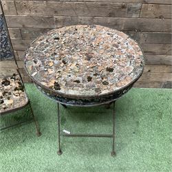 Circular metal garden table with tile top and matching chair, weathered