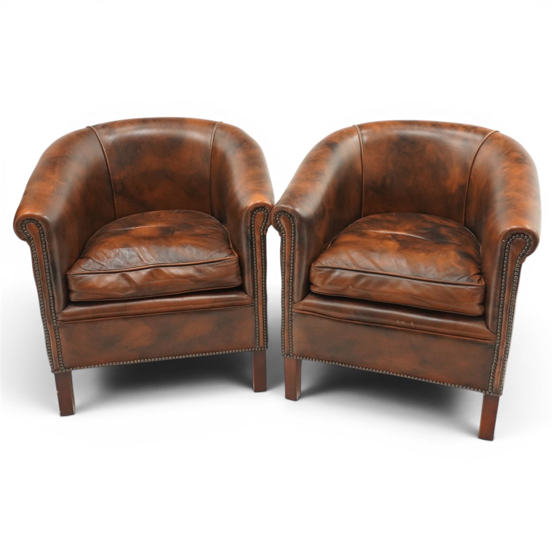 Pair of brown leather tub chairs, with downswept arms with brass studded trim, fixed cushion seat, raised on square tapering supports 