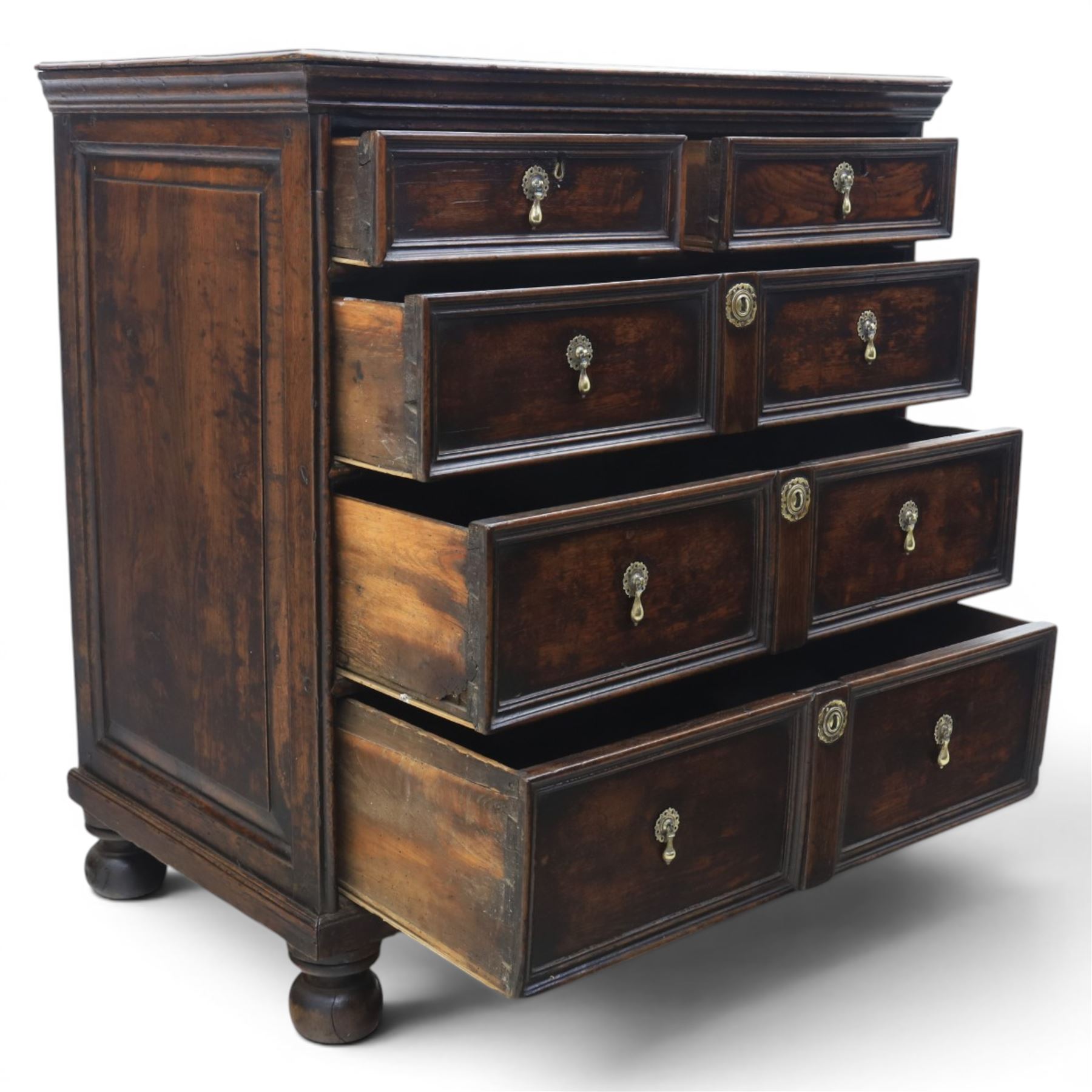 Late 17th century moulded front oak chest of drawers, rectangular plank top. above two banks of four graduated drawers, central escutcheons and drop handles, on squat bun feet