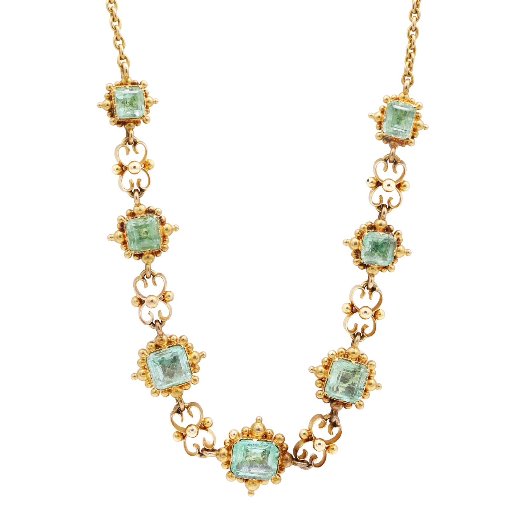 19th century gold emerald necklace, seven closed back octagonal cut and square cut emeralds, surrounded by a fancy bead setting, each spaced by a pierced scroll and bead design link, to a cable link chain necklace, with The Gem & Pearl Laboratory report