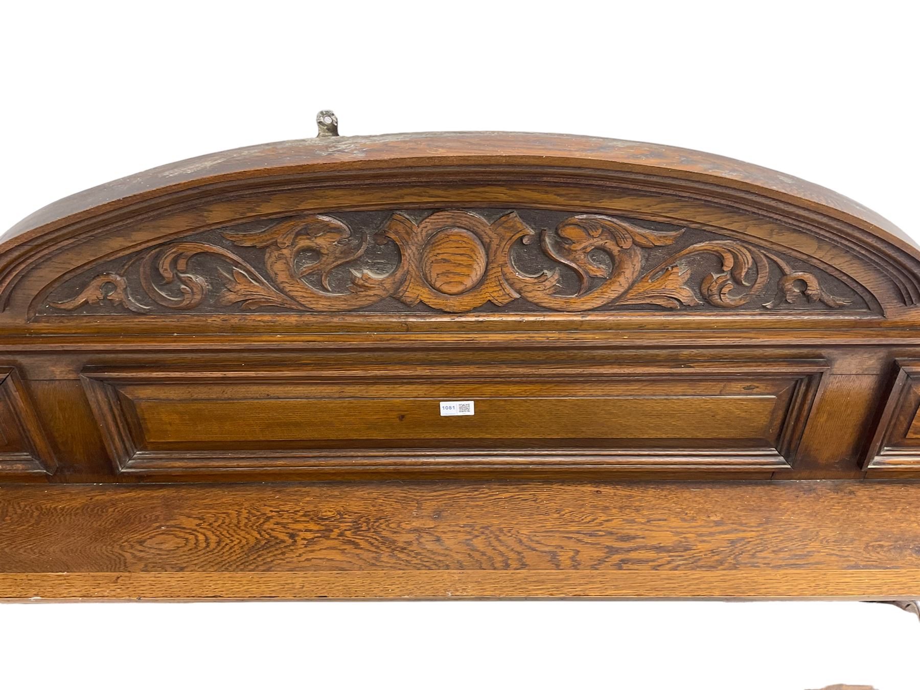 Oak overmantle mirror, arched pediment carved with shield and flanking fish with trailing scrollwork, panelled frieze over extending canopy raised by turned and fluted column pilasters, bevelled mirror plate 