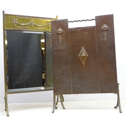  Arts & Crafts hammered copper fire screen on splayed feet, H71cm and an Edwardian brass fire screen with bevel mirror and floral garland mount (2)   