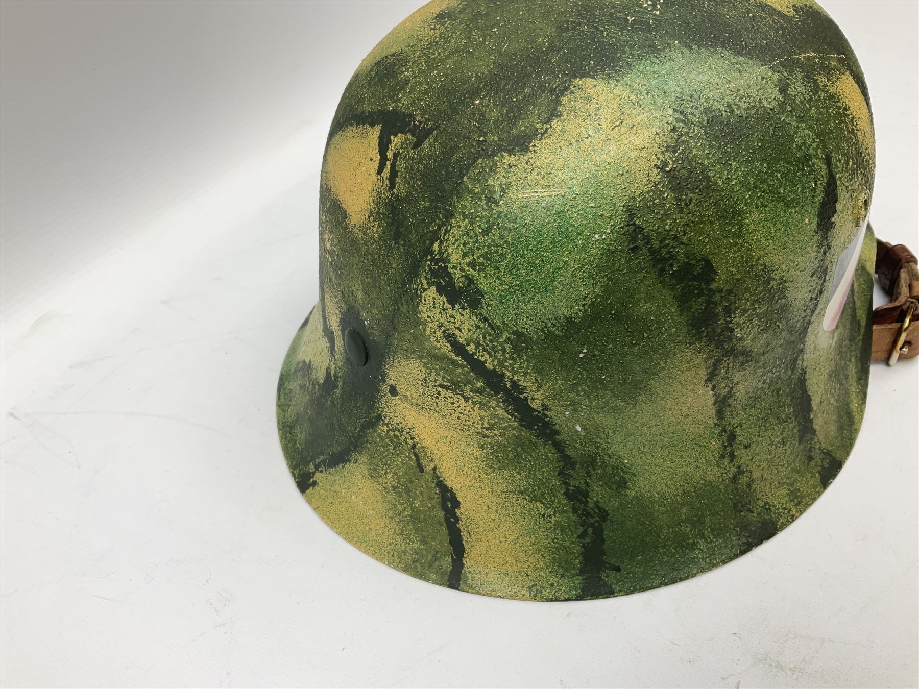 Fully restored German steel helmet, the camouflage painted exterior with two decals and replacement leather liner
