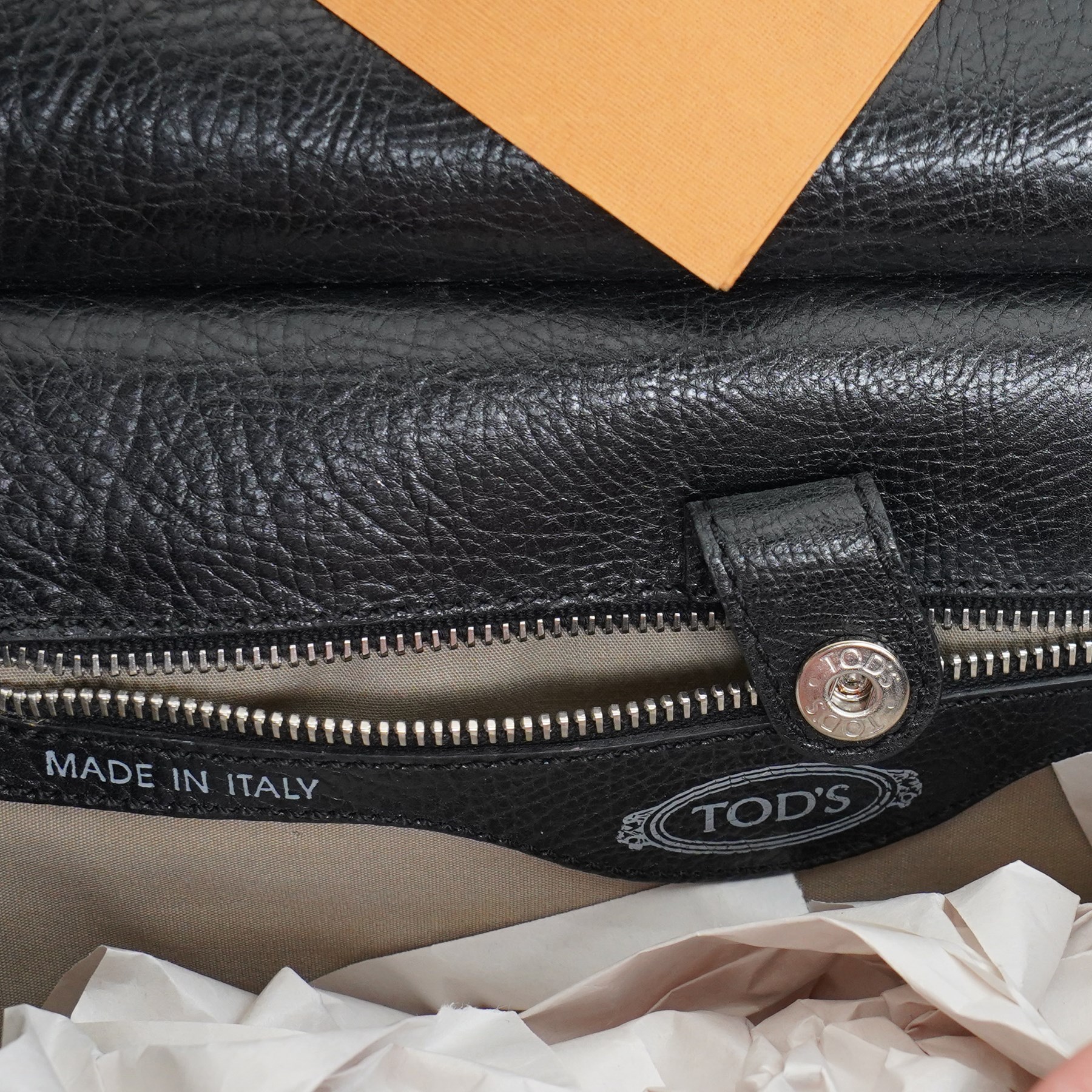 Tod’s - Fashion Pochette Piccola in Nero crinkled patent leather, the rectangular body with rolled-bar top, detachable wrist strap, flap front and silver-tone branded toggle fastening, with original product tag and dust bag