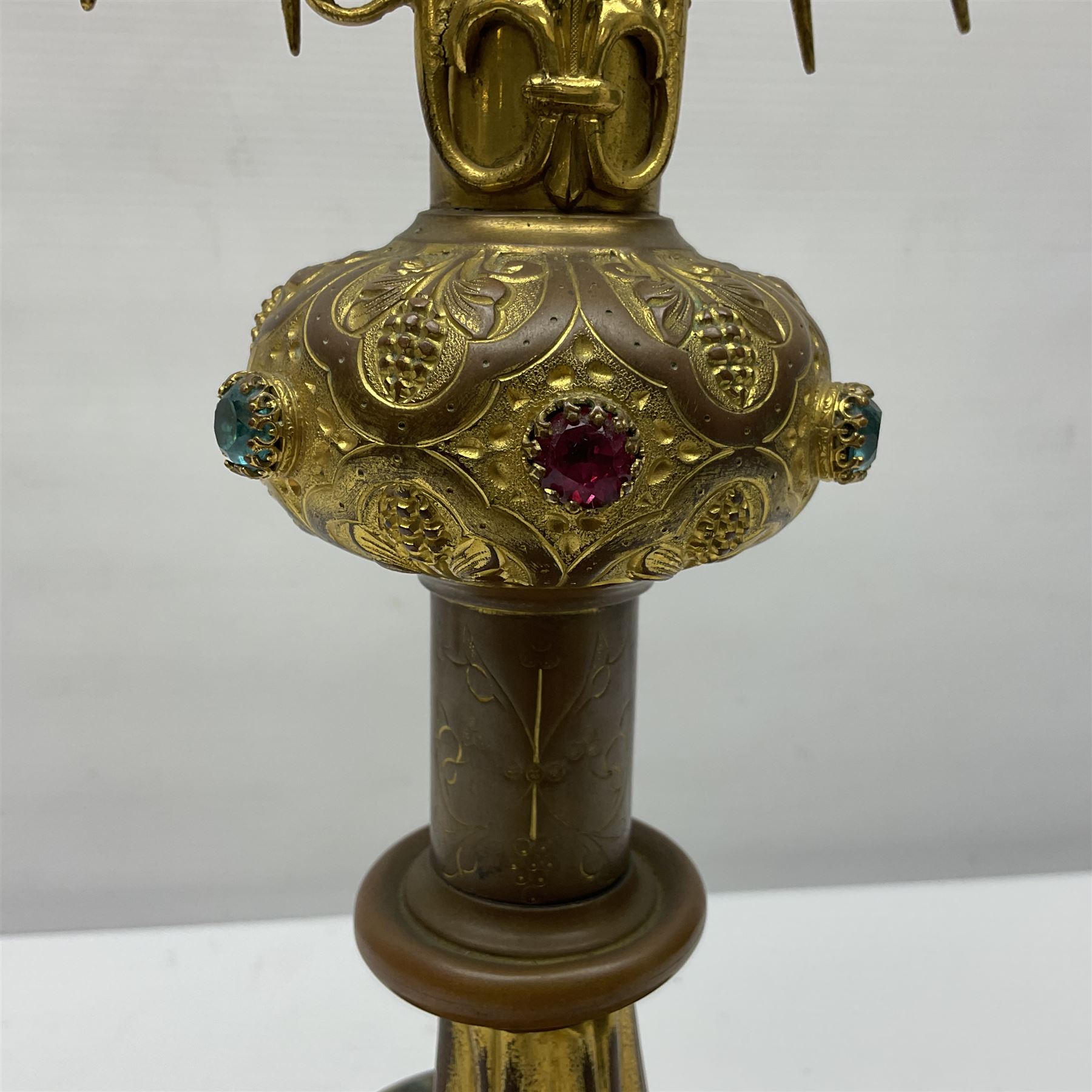 20th century gilt metal monstrance, in the Gothic revival style, with glazed aperture to centre surrounded with clear paste stones, in a pierced floral and scroll border set with coloured paste stones, within a sunburst surround, on a paste set knopped stem and similar foliate foot, H59.3cm