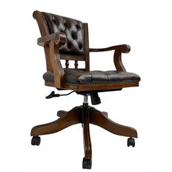 Georgian design stained beech swivel desk chair, the back carved with roundels and reeded decoration over spindle supports, upholstered in buttoned chocolate brown leather with studwork border, over a swivel and reclining action with splayed supports and castors