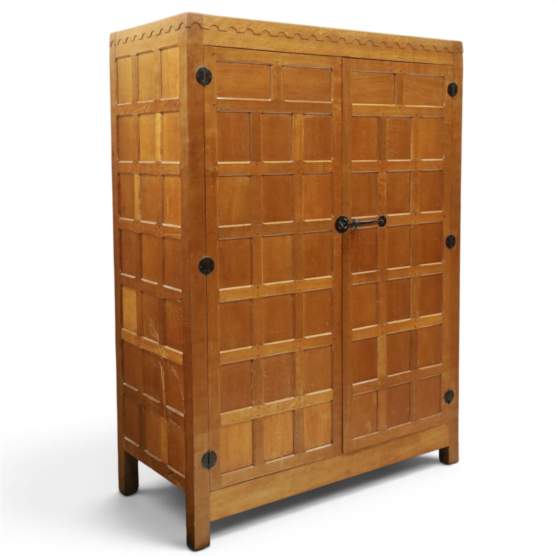 Mouseman - early-to-mid-20th century panelled and adzed double wardrobe, the arcade carved cresting rail over two panelled doors, with wrought metal hinges and latch, deep relief carved mouse signature, the interior fitted with hanging rail, by the workshop of Robert Thompson of Kilburn