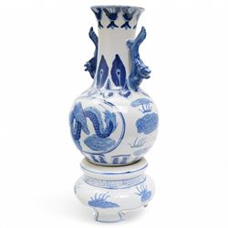Pair of Chinese blue and white vases and stands, of baluster form with elongated neck, decorated with painted scenes of dragons amongst clouds, the twin handles formed as two crouching dragons, including stands H32cm