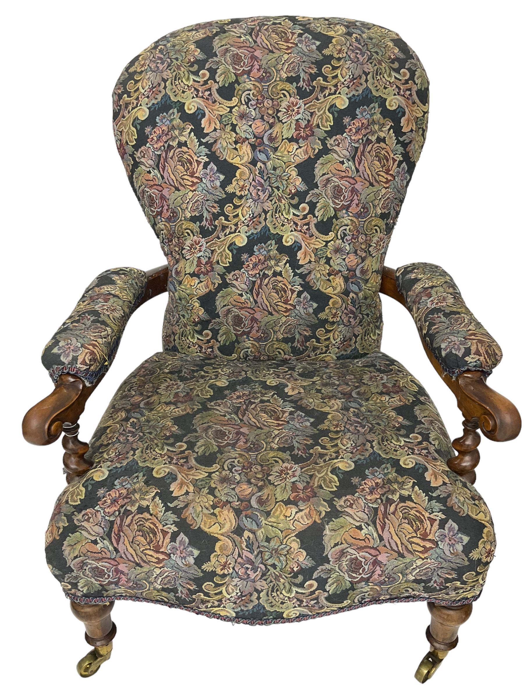 Victorian walnut framed open armchair, scrolled arm terminals over spiral turned arm supports, upholstered in foliate patterned fabric with sprung seat, on turned supports and brass castors (W65cm H92cm); and Victorian mahogany nursing chair with lobe carved supports (W60cm H92cm)