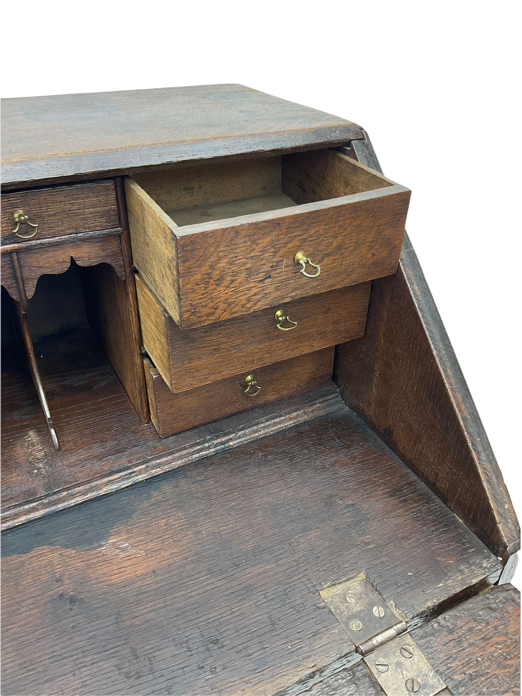 Georgian oak bureau, fall front enclosing fitted interior, four long graduating drawers, on bracket feet