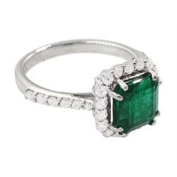 18ct white gold radiant cut emerald and round brilliant cut diamond cluster ring, with diamond set shoulders, stamped, emerald approx 1.80 carat, total diamond weight approx 0.50 carat