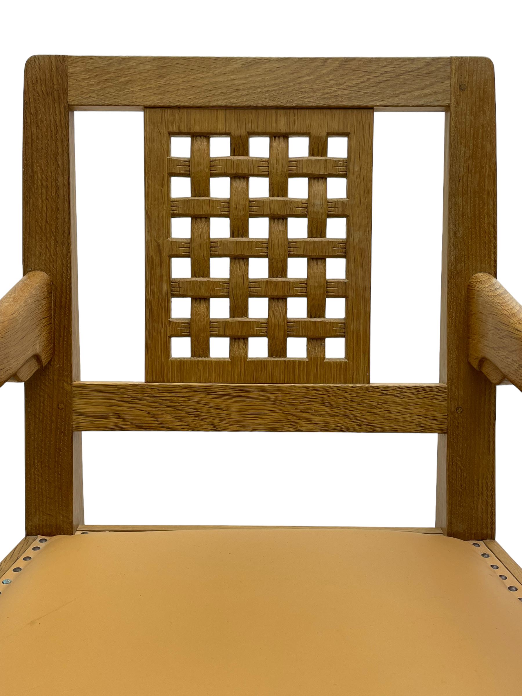 Mouseman - oak carver elbow chair, pierced and carved lattice back over leather upholstered seat with stud band, on octagonal supports united by plain stretchers, carved with mouse signature, by the workshop of Robert Thompson, Kilburn 