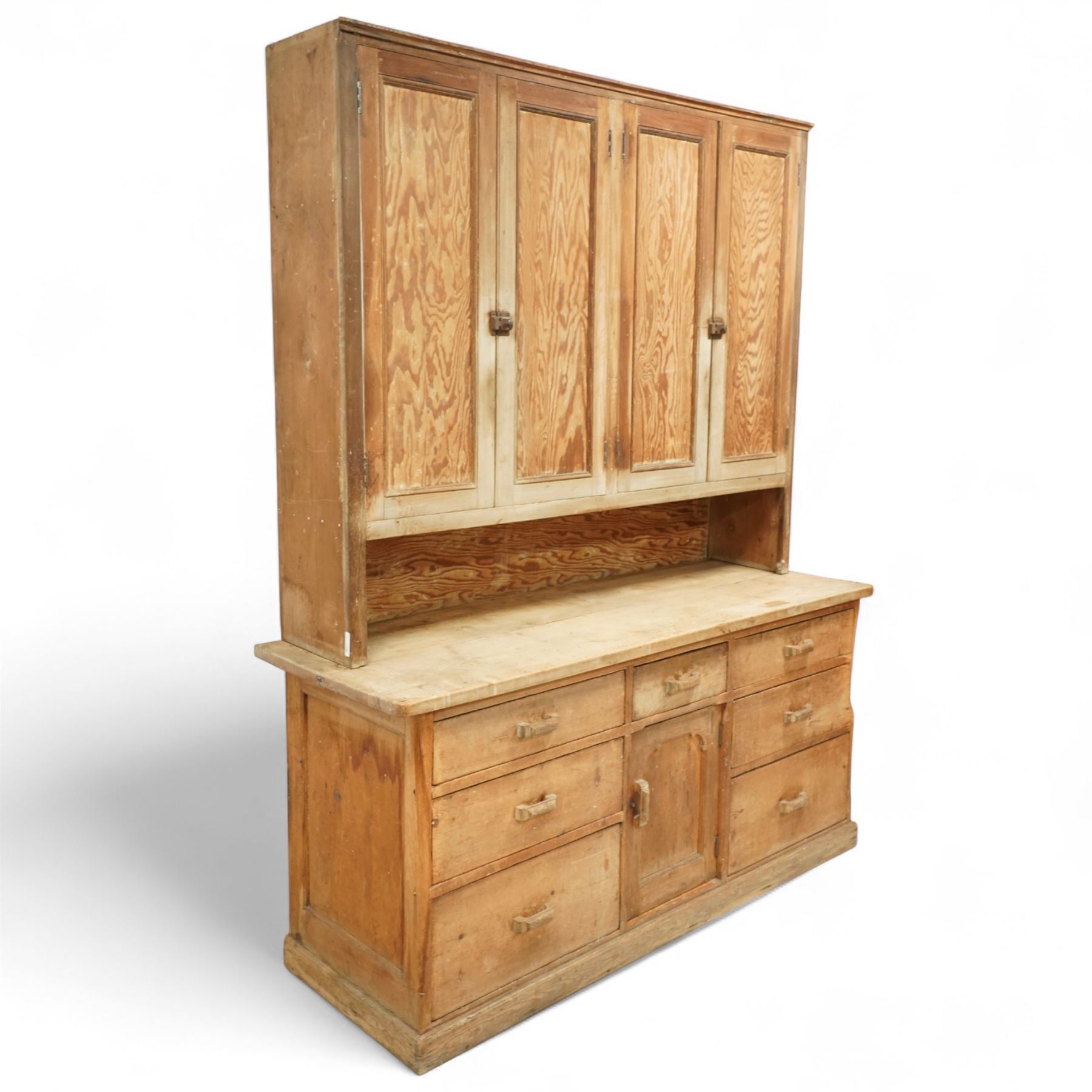 Early 20th century pine and beech kitchen dresser, projecting cornice above three panelled cupboard doors, base fitted with three drawers and twin panelled cupboards, on plinth base
