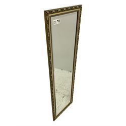 Gilt framed wall mirror, rectangular bevelled mirror plate enclosed by gilt-edged border with continuous wave pattern, outer border with oval medallions and foliate designs