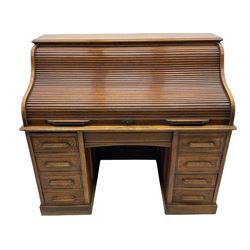 Early 20th century oak roll top desk, the tambour roll enclosing fitted interior, the pedestals fitted with two banks of four drawers