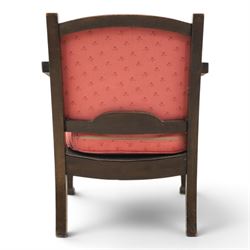 Early 20th century small oak open armchair, arched upholstered back with brass stud border over shaped seat cushion upholstered in pink foliate fabric, shaped open arms on square supports