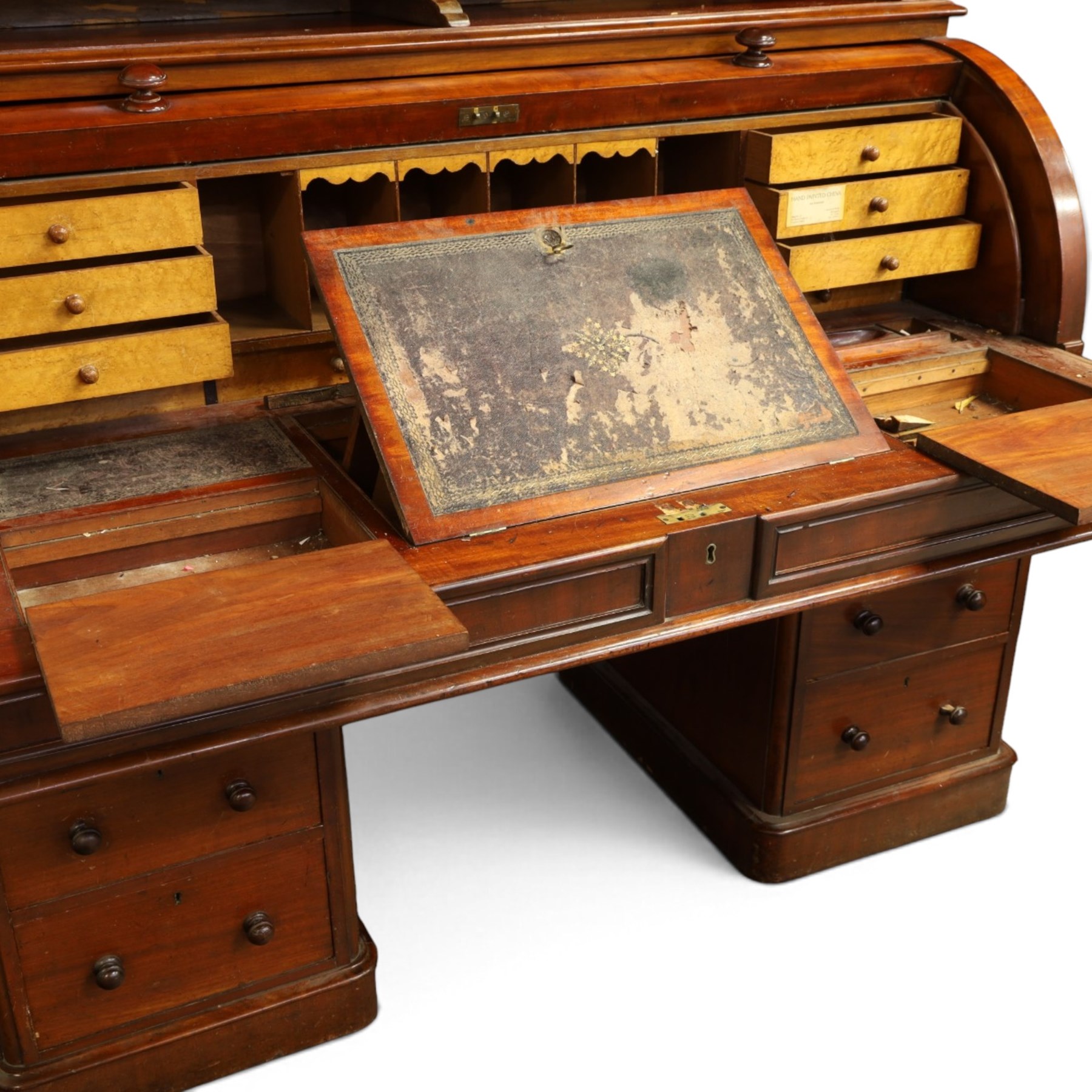 Victorian mahogany cylinder roll-top bookcase-secretaire, projecting cornice over twin glazed doors enclosing two shelves, the cylinder roll-top enclosing fitted interior with sliding drawer, hinged compartments, correspondence drawers and pigeon-holes, the twin pedestals fitted with three graduating drawers to each side, on plinth bases with castors