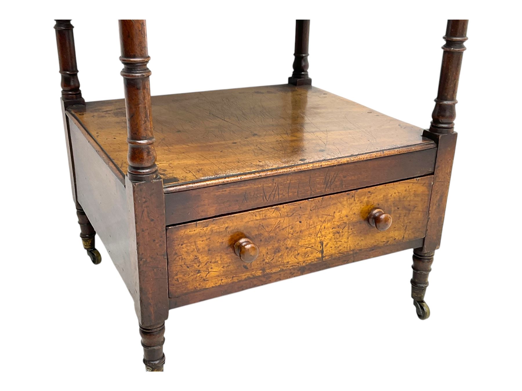 Early 19th century mahogany whatnot, with four rectangular shelves, the lower shelf fitted with a single drawer, supported by slender turned columns, raised on turned supports with brass castors