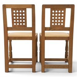 Mouseman - set of four oak lattice back chairs with tan seat with brass studded trim, with carved mouse signature, by the workshop of Robert Thompson of Kilburn