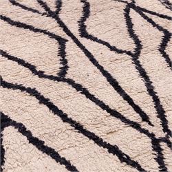 Moroccan Berber wool hand knotted rug, the cream ground decorated with abstract diamond forms and angular lines in dark brown, enclosed by a simple patterned border, with short fringe ends