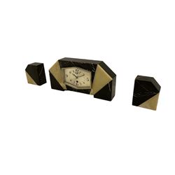 A 1930s French/Belgium Art Deco mantle clock in a black and cream “Sun Ray” marble case with two corresponding garnitures, hexagonal shaped silvered dial with Art Deco Arabic's and corresponding chrome bezel (glass missing), Fleur de Lis chrome hands, dial inscribed “UCRA”, with a timepiece pin pallet movement.
Clock H20 W40 D8  Garnitures H14 W12 D7



