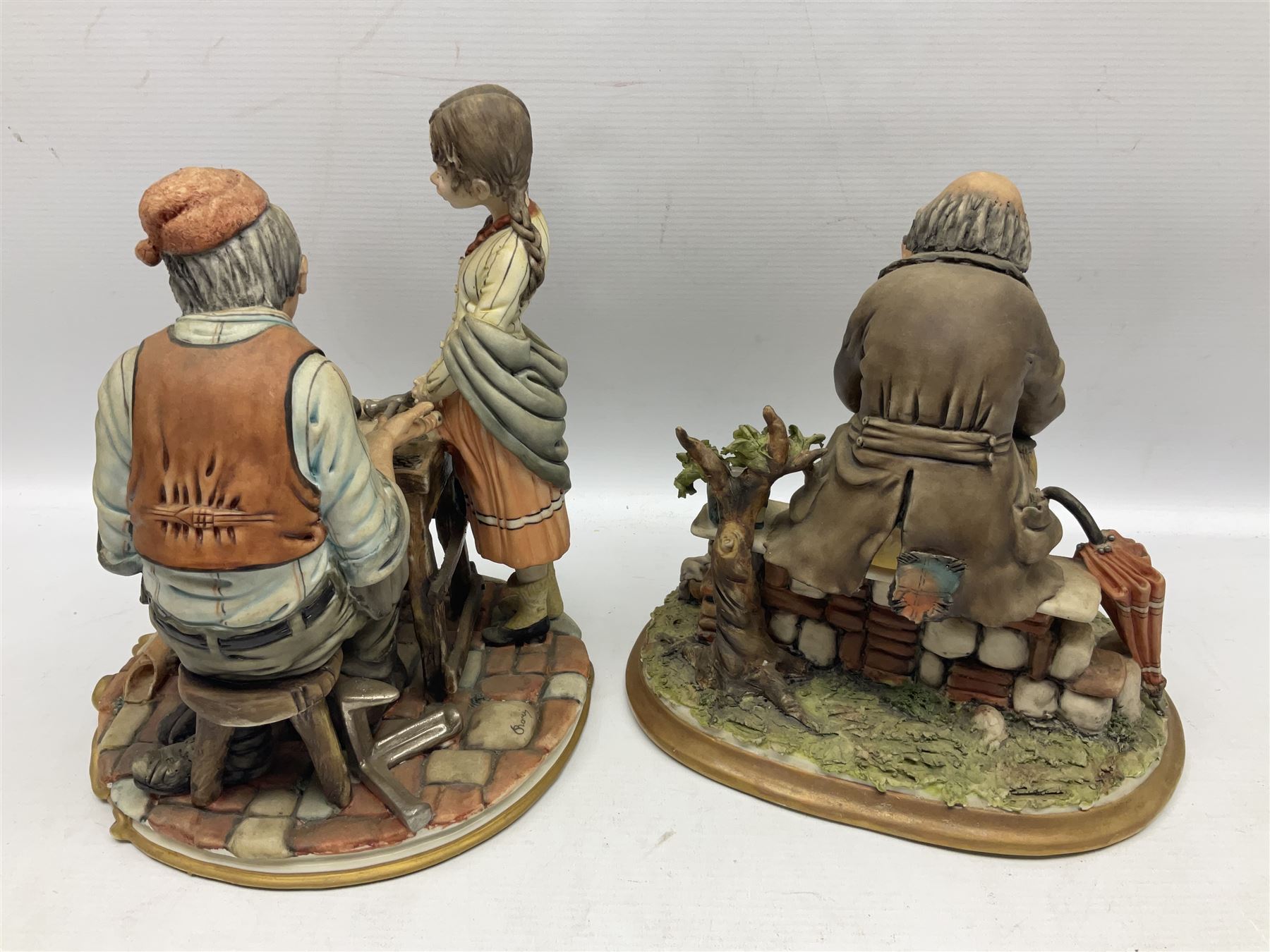 Four Capodimonte figure groups, to include tramp figures, shoemaker figure etc