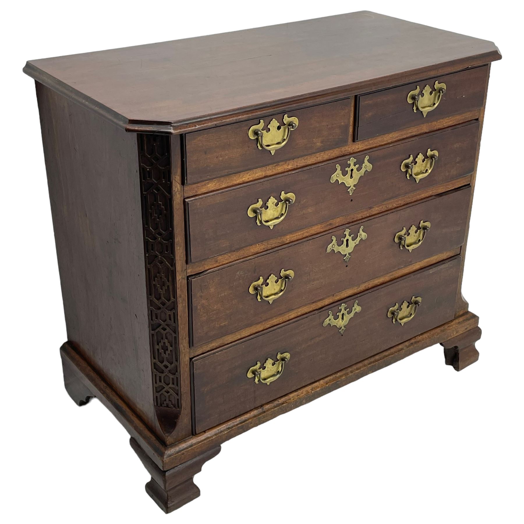 George III Chippendale design mahogany chest, moulded rectangular top with canted corners, wide canted uprights with blind fretwork decoration, two short and three long with moulded fronts, shaped brass handle plates, on ogee bracket feet 