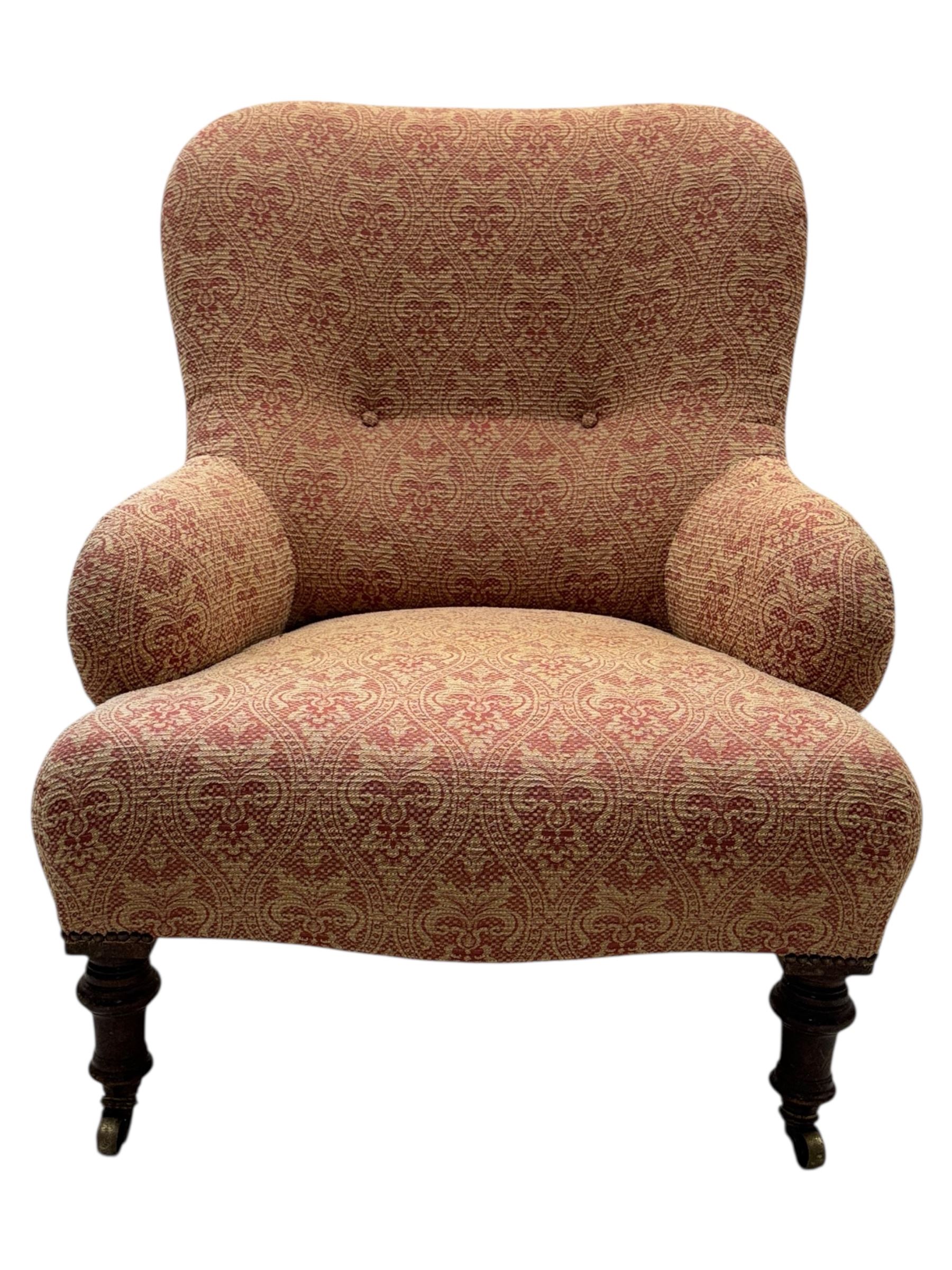 Late Victorian upholstered armchair, with high camel back and deep seat, padded arms and backrest in crimson and cream damask-style fabric, raised on turned ebonised front supports with ceramic castors (H88cm, W65cm, D 60m); and an Edwardian bedroom chair with button upholstered rail back (H72cm, D64cm, W53cm) (2)