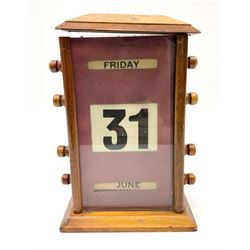 An early 20th century oak perpetual desk calendar, with three glazed apertures for day, date and month, H20cm