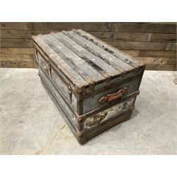 Early 20th century wood and metal bound zinc travelling trunk, hinged top with three clasps, decorated with period luggage labels