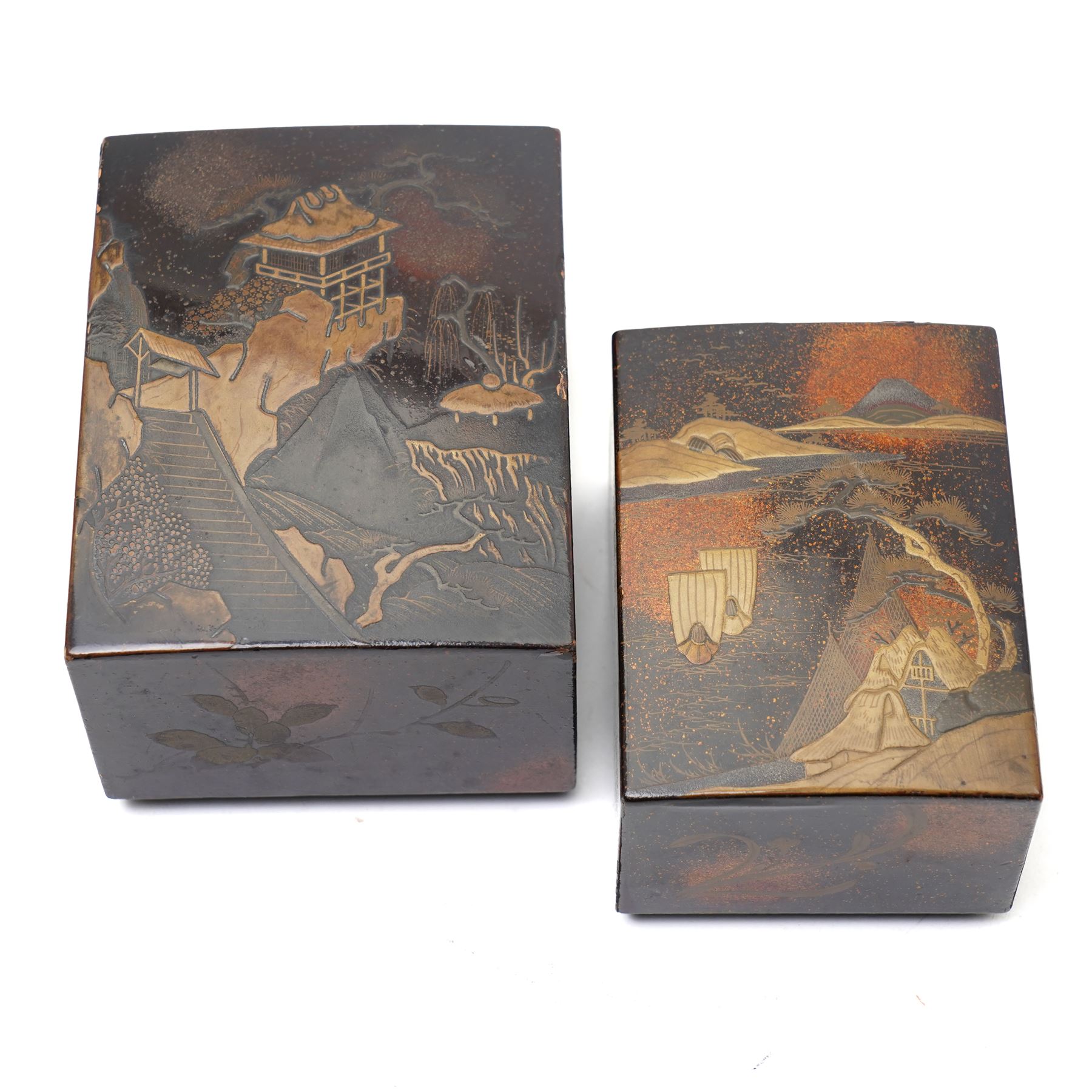Nest of Japanese Meiji period lacquered boxes, the nashiji ground with maki-e decoration, each cover depicting a traditional landscape, the sides painted with traditional Japanese foliage, larger box H7cm (2)