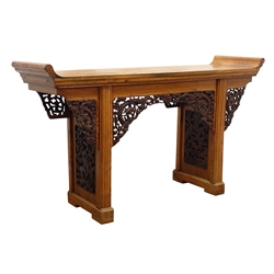  Chinese hardwood altar table, the long oblong top with upward curving ends on two supports with carved panels to either side depicting Ho Ho bird amongst blossom and a dragon over a bridge and fish, with similarly carved corner brackets, W170cm, H96cm, D48cm  
