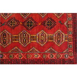 Persian Baluchi crimson ground rug, decorated with three columns of geomtric motifs