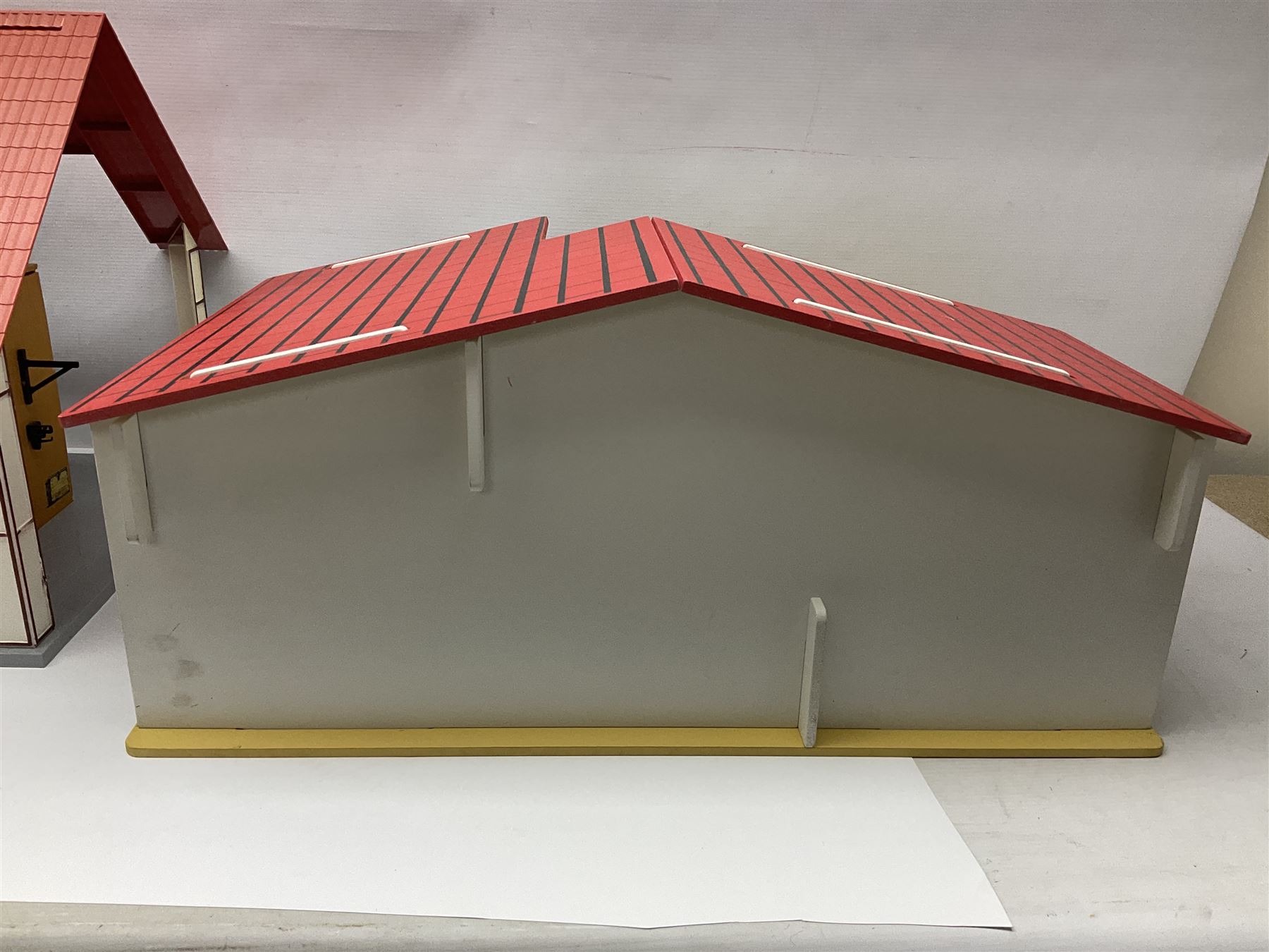 Sectional wooden horse stables playset by Julip with two stalls and tack room under a pitched roof, base 59 x 47cm; and another sectional plastic stables playset by Schleich with three stalls under an open pitched roof, base 56 x 36cm (2)
