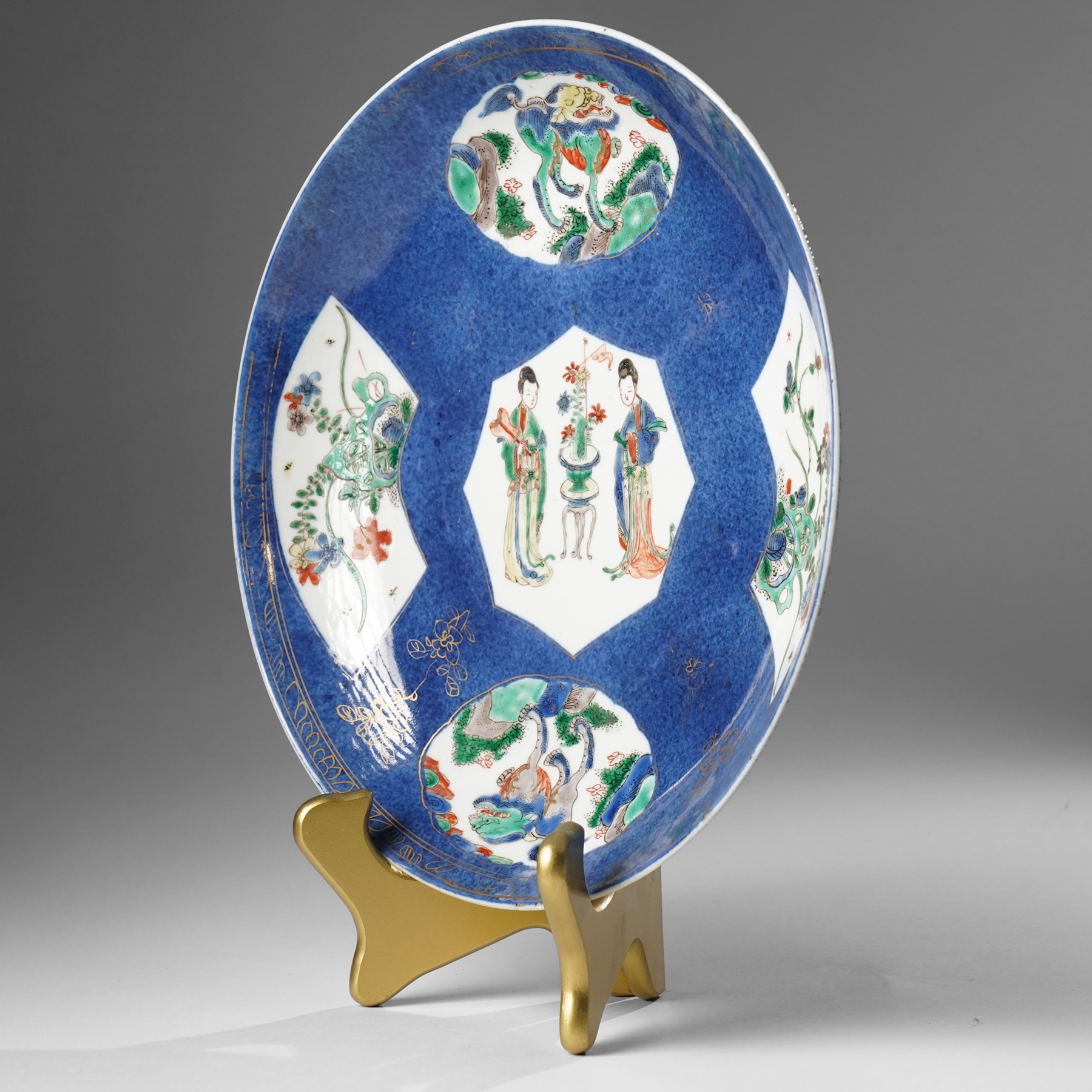 Chinese powder blue ground famille verte charger, possibly Kangxi, decorated with a central cartouche enclosing two female figures, with smaller shaped panels enclosing lions and foliage, square seal mark in blue to base, D28cm
